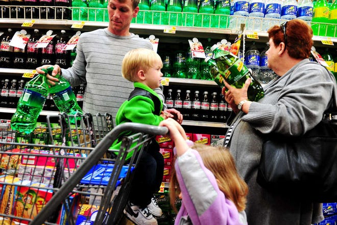 Phillip Williams Jr., of Augusta, shops for groceries with his children, Peyton (in buggy) and Alyssa, and his mother, Gloria Williams.