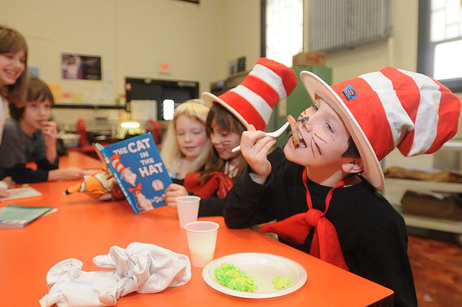 From left, Ollivia Weber and Delaney Rasnussen, read "The Cat In The Hat" while Jack Joyce enjoys some green eggs and ham.
