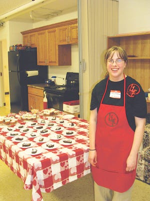 Holly Randall, LIFE Academy student, poses by a table full of desserts in the classroom that was turned into a studio apartment for LIFE students to learn everyday skills. The Heart of Morton Foundation is looking for ways to continue education for developmentally disabled children who age out of District 709. GateHouse News Service