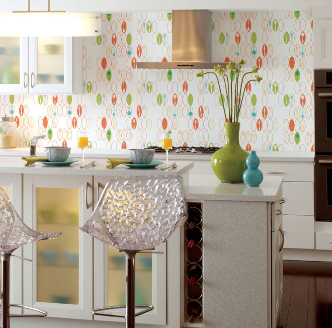 A wallpaper design showing kitchen utensils in ovals in teal, salmon, lime on white are shown in a kitchen display.