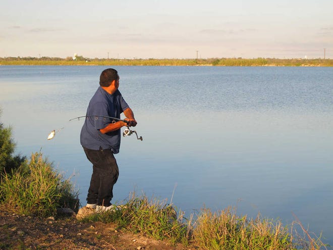 Joe Garcia fishes along Donna Reservoir in Donna. The lake's fish have long been known to carry harmful chemicals, but fishermen keep coming back in spite of warning signs.