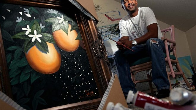 Kelvin Hair in his home studio with a painting that was selected for display in the state capital for Black History Month.