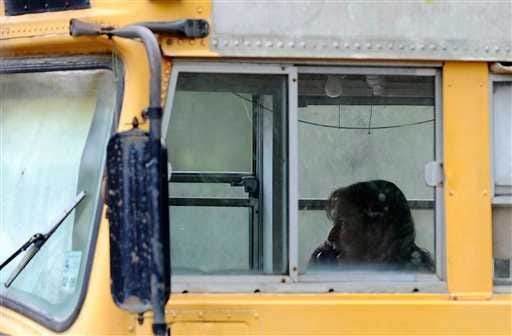 An unidentified woman talks on a phone inside a dilapidated converted school bus Thursday, March 8, 2012, in Splendora, Texas. Two young children found Wednesday living in the stench-filled bus near Houston are in the custody of Texas child welfare workers. (AP Photo/Pat Sullivan)