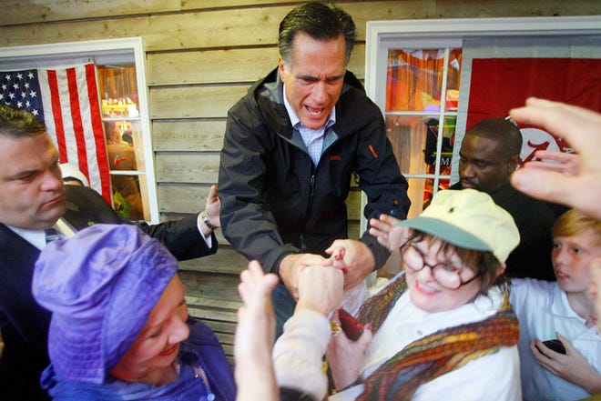 Republican presidential candidate, former Massachusetts Gov. Mitt Romney greets supporters who braved the rain during a campaign stop at the Whistle Stop Cafe, Monday, March 12, 2012 in Mobile, Ala. (AP Photo/ John David Mercer)