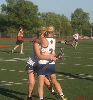 Marcus Whitman players Molly Gray, left, and Meg Robson embrace after the final whistle of the Section 5 Class C finals in Penn Yan. It is the school's first girls lacrosse title.
