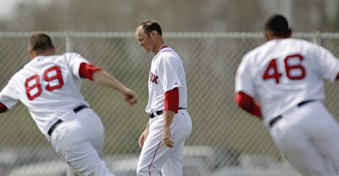 Boston Red Sox pitcher Jon Lester, center, walks back to the end of the line after completing a running drill during a baseball spring training workout Sunday, Feb. 26, 2012, in Fort Myers, Fla. (AP Photo/David Goldman)