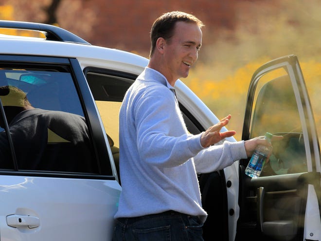 In this March 11, 2012 file photo, NFL quarterback Peyton Manning waves to fans as leaves the Arizona Cardinals training facility in head coach Ken Whisenhunt's car after a five hour meeting, in Tempe, Ariz. Titans coach Mike Munchak, general manager Ruston Webster and owner Bud Adams' top executive in Tennessee have taken off in the team's private plane headed for a meeting with Manning. (AP Photo/Ross D. Franklin, File)