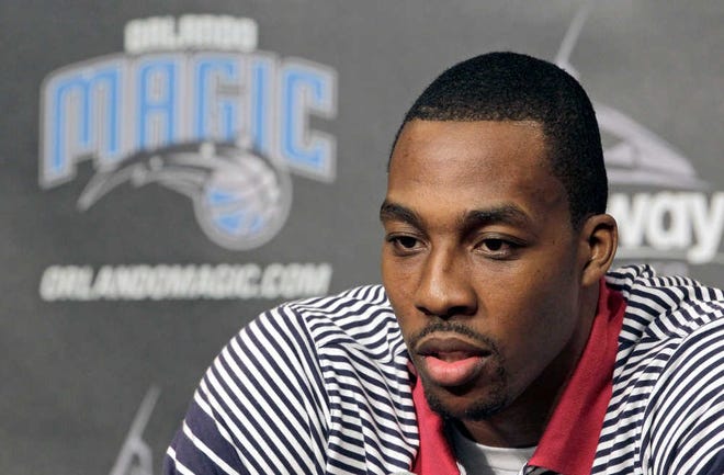 Orlando Magic center Dwight Howard answers questions during a news conference,Thursday, March 15, 2012, in Orlando, Fla. Howard announced he will remain with the Orlando Magic NBA basketball team through next season.(AP Photo/John Raoux)