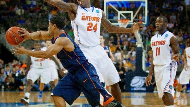 Florida's Casey Prather (24) and Erving Walker (11) put on a full-court press against Virginia's Jontel Evans during the half of an NCAA college basketball tournament game in Omaha, Neb., Friday, March 16, 2012.