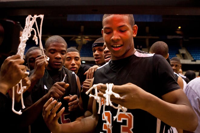 Lanphier senior Lance Boozer (33) gets his piece of the net after Lanphier defeated East St. Louis in the Class 3A Springfield Supersectional at the Prairie Capital Convention Center in Springfield, Ill., Tuesday, March 13, 2012.