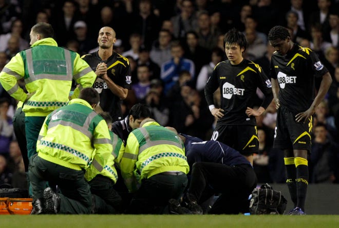 Bolton Wanderers' Fabrice Muamba is obscured by medical staff trying to resuscitate him after collapsing as his teammates, from left, Darren Pratley, Ryo Miyaichi and Dedryck Boyata react during the English FA Cup quarterfinal soccer match between Tottenham Hotspur and Bolton Wanderers at White Hart Lane stadium in London, Saturday, March 17, 2012. Bolton midfielder Fabrice Muamba has been carried off the field at Tottenham after medics appeared to be trying to resuscitate him during an FA Cup quarterfinal that was abandoned. Muamba went to the ground in the 41st minute with no players around him and the game was immediately stopped. (AP Photo/Matt Dunham)