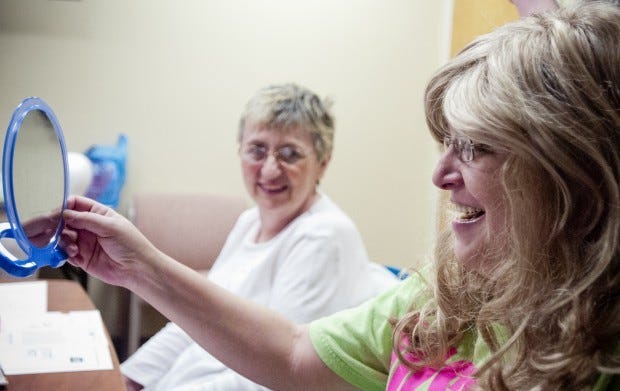Sharon Baron of Hopewell Township looks on as Rachael Straub of Rochester tries on a wig that she calls her "Kim Zolciak ('Real Housewives of Atlanta')" hair, during the Look Good ... Feel Better program at Heritage Valley Beaver hospital on March 13.