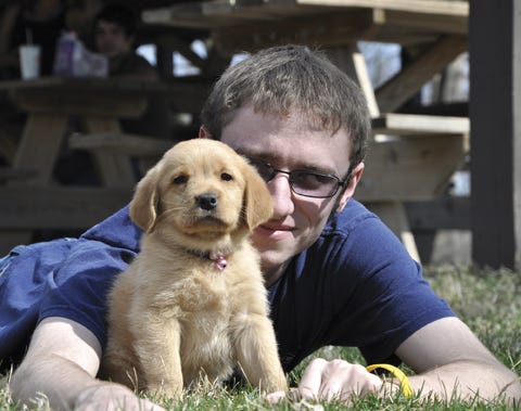 Travis Orban of Pontiac and his puppy, Addie, both enjoy the feel of warm grass in Chautauqua Park Friday. The city parks were popular places with this week’s warm weather.