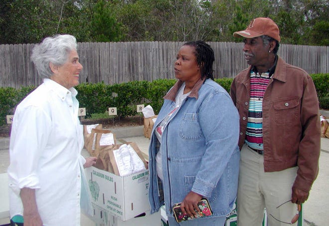 Pilot Kay Burton, from left, discusses caladiums with Donita and Alphonso Waddley.