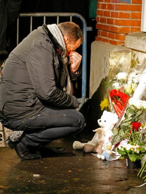 A man pays respect to victims at a makeshift shrine, at the Ozar Hatorah Jewish school where a gunman opened fire killing four people in Toulouse, southwestern France, Monday, March 19, 2012. A father and his two sons were among four people who died Monday when a gunman opened fire in front of a Jewish school in a city in southwest France, the Toulouse prosecutor said Monday.(AP Photo/Remy de la Mauviniere)