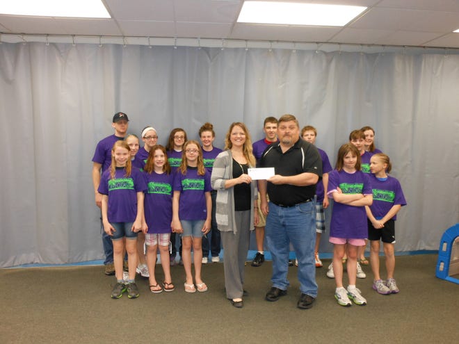 Jon Johnson of the Canton Park District (at right) presents Candy Johnson, Swim Team President for the Can-Y-Cuda's, with a donation to help the team. Joining in are swim team members (in no particular order) Khristie Brooks, Tovah Brooks, Erin Burton, Piper Burton, Hannah Grant, Miranda Hammond, Allison Jackson, Meagan Jackson, Jake Johnson, Luc Pritchard, Sarah Rowe, Saydey Shubert, Hannah Watts, Julia White, Emelia Smith (not pictured), and Eileen Urish (not pictured) as well as the coaches, Carey Brooks, Aubrey Brooks, and Karol Herink.