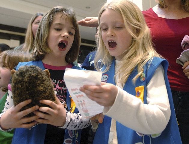 John Huff/Staff photographer 
Daisey troop 10931 members Lillie Chandler, 7, left, and Danielle Young, 6, sing songs as they participate in a flash mob with other Girl Scouts from the seacoast region at the Fox Run Mall Sunday to celebrate the Girl Scouts' 100-year anniversary.