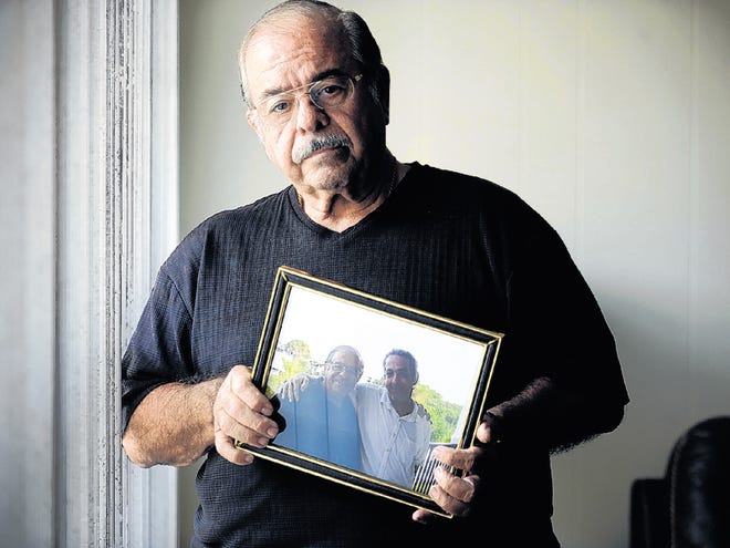 Ralph Ameduri, Sr. holds his favorite photo of he and his son, Ralph Ameduri, Jr., taken on Father's Day , photographed in Orlando. Monday, December 5, 2011