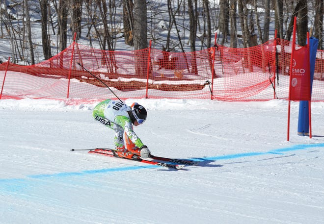 Marcus Whitman junior Connor Kelly reaches across the finish line at the FIS Eastern Junior Finals in Okemo, Vt.