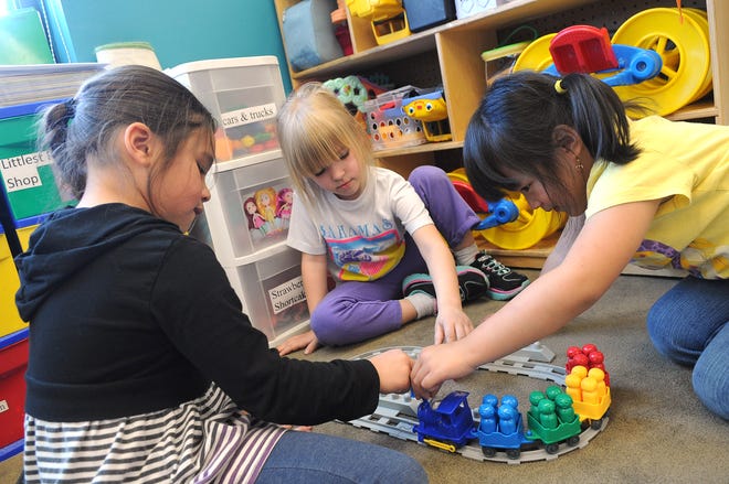 Kyara Fernandez, 6, from left, Hanna Kathleen, 5, and Debbie Seemeuang, 5, work together to build a train during free time in Cheryl Dewey’s all-day kindergarten class in the Angelo Elementary School in Brockton on Monday.