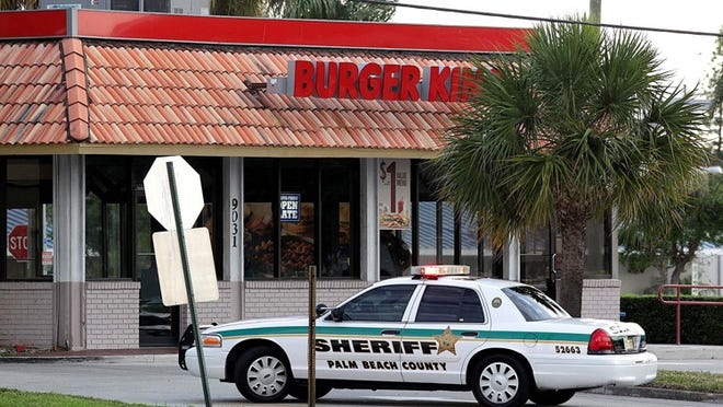 Palm Beach County Sheriff's deputies cordon off the parking lot at a Burger King at Northlake Boulevard and Old Dixie Highway Tuesday, March 20, 2012. An armed robbery by at least one suspect wearing a President Barack Obama mask took place at the restaurant this morning.