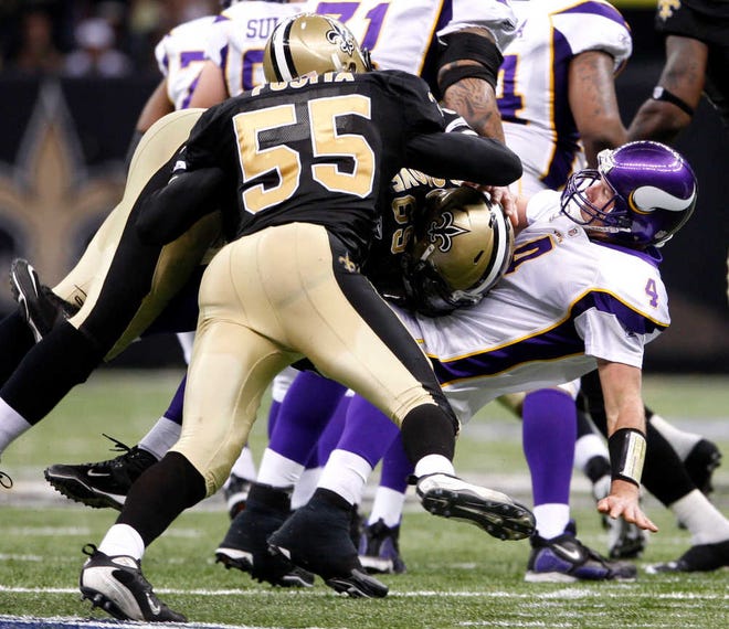 Minnesota Vikings quarterback Brett Favre (4) is hit by New Orleans Saints linebacker Scott Fujita (55) and Anthony Hargrove during the fourth quarter of the NFC Championship NFL football game in New Orleans, on Jan. 24, 2010. The Saints were flagged twice for roughing Favre.