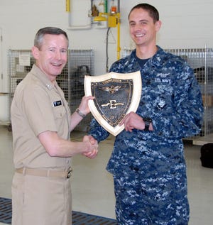 Commander, Naval Air Force, U.S. Atlantic Fleet Rear Adm. Ted Branch presents the Battle "E" Award to AO1(AW) Michael Atkinson of VP-10 during an all hands quarters on Feb. 21.