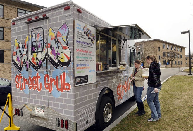 Assumption College students Jen Reardon, left, of Lunenburg, and Sarah Jones of Indonesia, check out the offerings at Oxedos Street Grub, a food truck that will be on campus several times a month.