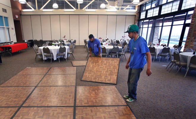 Party Creations employees Tyler Coleman, right, and Aquino Shephard set up a portable dance floor for a wedding and reception for Kristoffer and Amanda Barrington on March 17 at Erin's Pavilion in Southwind Park.