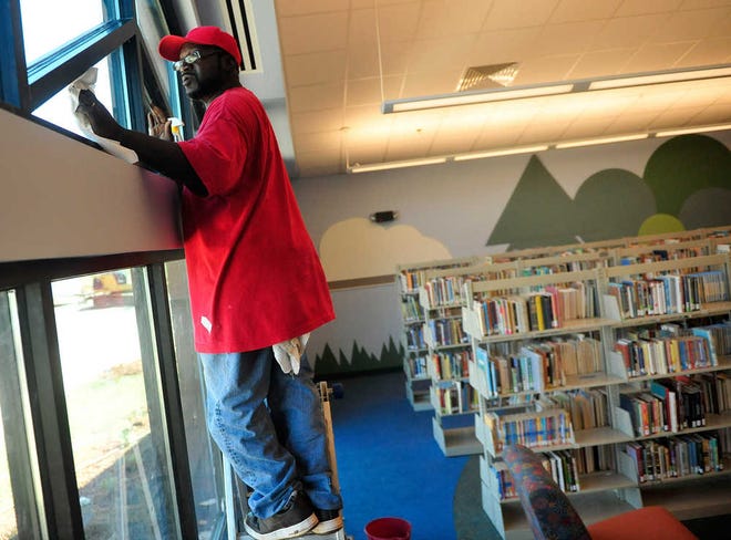 Richard Hamm/Staff Cecil Clark cleans windows in preparation for a ribbon cutting ceremony to reveal the recently remodeled Madison County Public Library on Monday, March 26, 2012 in Athens, Ga.