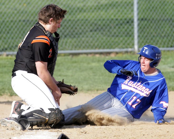 Tuslaw designated hitter Johnathan Ryan slides home against Dalton catcher Cory Merriman during Tuesday’s game at Dalton. Ryan scored the Mustangs’ first run on a throwing error and Tuslaw went on to a 6-4 win.
