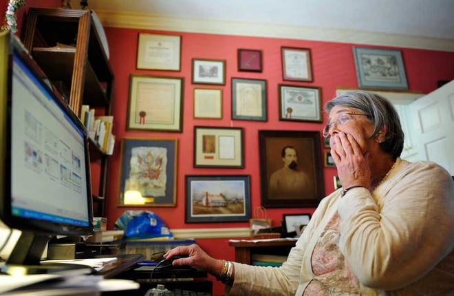 Becky Dozier searches through data on her computer. Dozier has tracked her family lines back to Colonial North Carolina and has helped other families research ancestors.