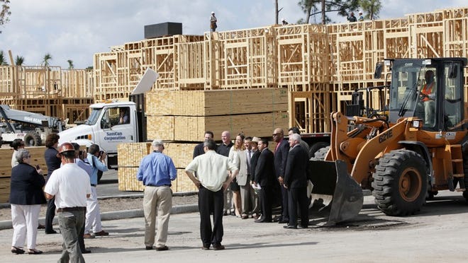 Government and construction company officials gather for a photo in front of Colonial Lakes Apartments Thursday morning.