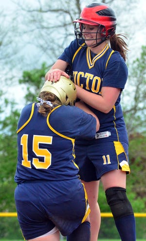 Victor's Delaney Escher (11) congratulates Bethany DeMarco (15) on a game winning hit while hosting Penfield on Wednesday, May 18, 2011.
