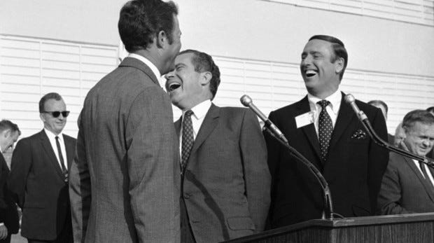 In this Oct. 10, 1968, file photo Republican presidential candidate Richard Nixon, center, laughs at something comedian Dick Martin, right, says during a rally in Burbank, Calif. Some decidedly unfunny candidates have benefited by exceeding extremely low expectations when it comes to jokes. When Nixon went on the TV comedy show "Rowan & Martin's Laugh-In" in 1968 and said "Sock it to ME?" he got rave reviews.