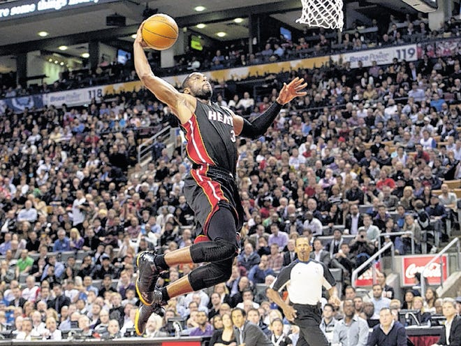 Miami Heat guard Dwyane Wade dunks the ball while playing against the Toronto Raptors during first-half NBA basketball game action in Toronto, Friday, March 30, 2012