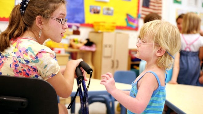 Volunteer Morgan Patipa, 13, talks to preschool pupil Laura Phillips, 4, Wednesday at the Palm Beach Rehabilitation Center for Children and Adults. ‘I have a special relationship with each one of them,’ Morgan said about the pupils.
