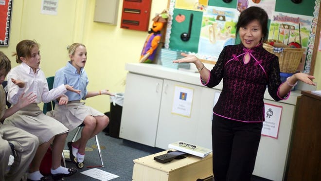 Day Academy teacher Louisa Perolio leads a fifth-grade music class in a song in Mandarin.