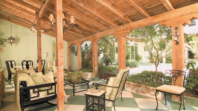 With its pecky-cypress ceiling, an expansive loggia off the breakfast room looks out to the courtyard at this vintage home on Seaspray Avenue. The house and its guesthouse are listed for sale at $3.25 million by Brown Harris Stevens.