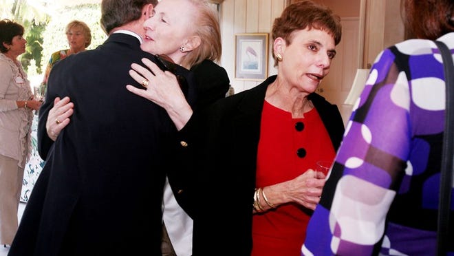 Renata Jones hugs Jerry LoBianco while Carole LoBianco talks to Kitty Lanier during a farewell party Wednesday. The LoBiancos, who ran The Church Mouse for 12 years, are retiring.