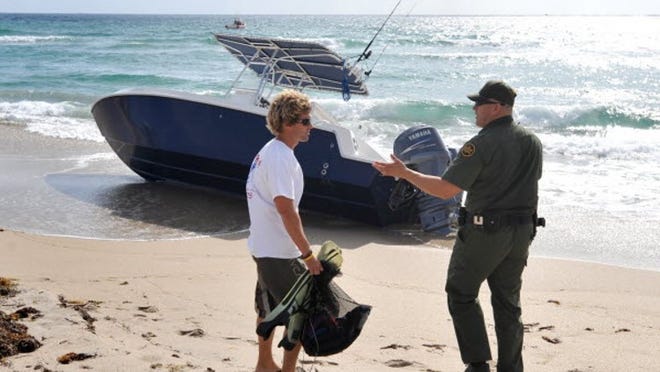 Ryan Helmis with Tow Boat U.S. and Alex Mederos with the U.S. Border Patrol approach a boat Wednesday that carried undocumented immigrants.