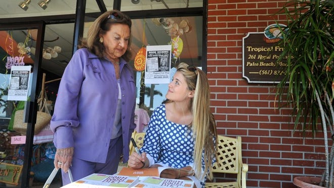 Author Daphne Oz, seated, signs a copy of her book, ‘The Dorm Room Diet,’ for Jerré Gowdy Thursday at the Tropical Fruit Shop. The book is geared toward college students.