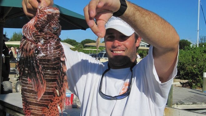 Bobby Leidy holds the largest and smallest fish that others caught in the derby June 19 in the Bahamas.