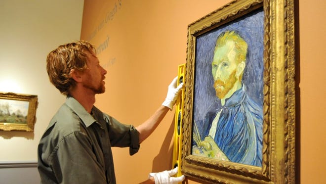 Senior art handler Kevin Cummins uses a level to position the van Gogh on the wall, where it will hang until Feb. 8.