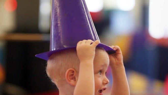 Harrison Warwick, 2, of Palm Beach, balances a purple traffic cone on his head.