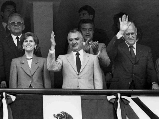 Former Mexican President Miguel de la Madrid, center, waves to the crowd after the opening ceremony of the Soccer World Cup tournament in Mexico City on May 31, 1986. Mexico's President Felipe Calderon announced on April 1, 2012, that Miguel de la Madrid has died at age 77. (AP Photo, File)