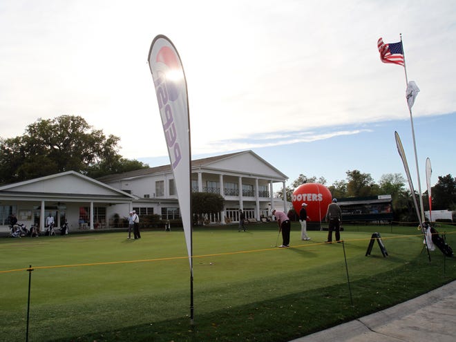 In this March 10, 2011 file photo, golfers practice on the putting green in front of the clubhouse during the first round of the Harley Davidson of Ocala Classic NGA Hooters Pro Golf Tournament at the Golden Hills Golf and Turf Club. The club reopens Tuesday under new management.