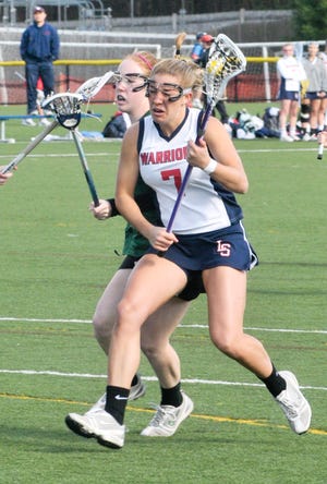 Lincoln-Sudbury's Maddy Acton, who scored eight goals, works the ball up the field against the Westwood defense during the Warriors' 13-12 win.