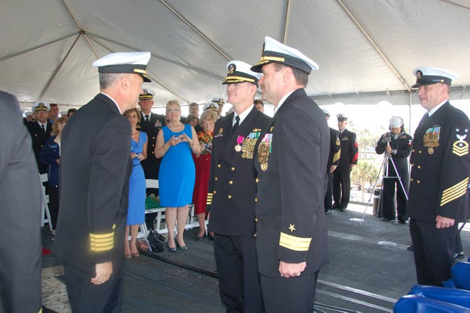 Capt. Dan Uhls reports as the new commanding officer of USS Hué City to Rear Adm. Michael Manazir, Commander Carrier Strike Group Eight, after taking command from Capt. Paul Stader during a change of command ceremony on board the ship on March 29.