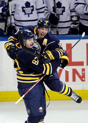 Buffalo Sabres' Derek Roy (9) celebrates his game-winning goal in overtime with teammate Marcus Foligno (82) in their 6-5 win over the Toronto Maple Leafs in an NHL hockey game in Buffalo, N.Y., Tuesday, April 3, 2012. (AP Photo/David Duprey)